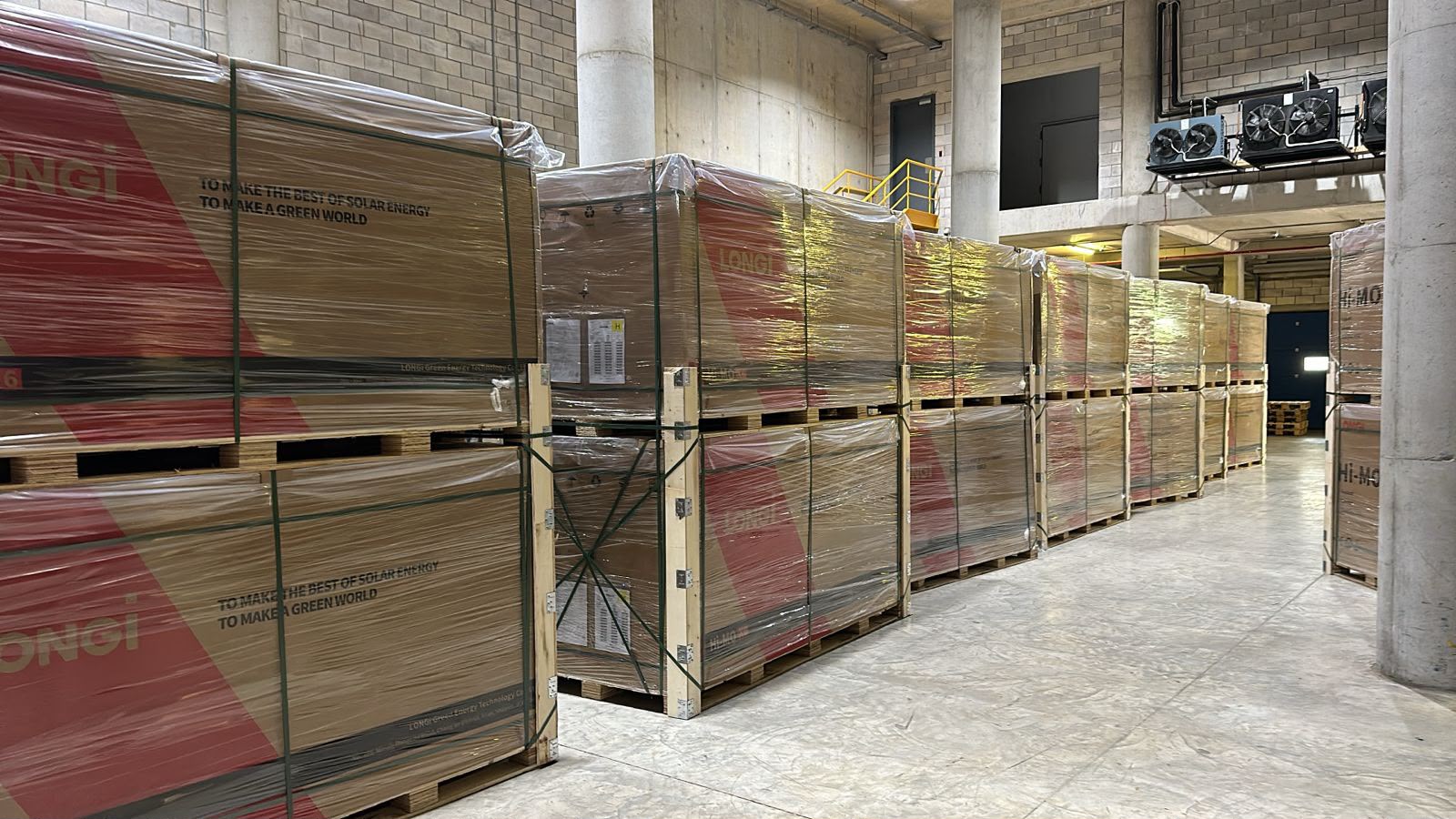 Aisle of palletised LONGi solar panels in the GreenWise warehouse
