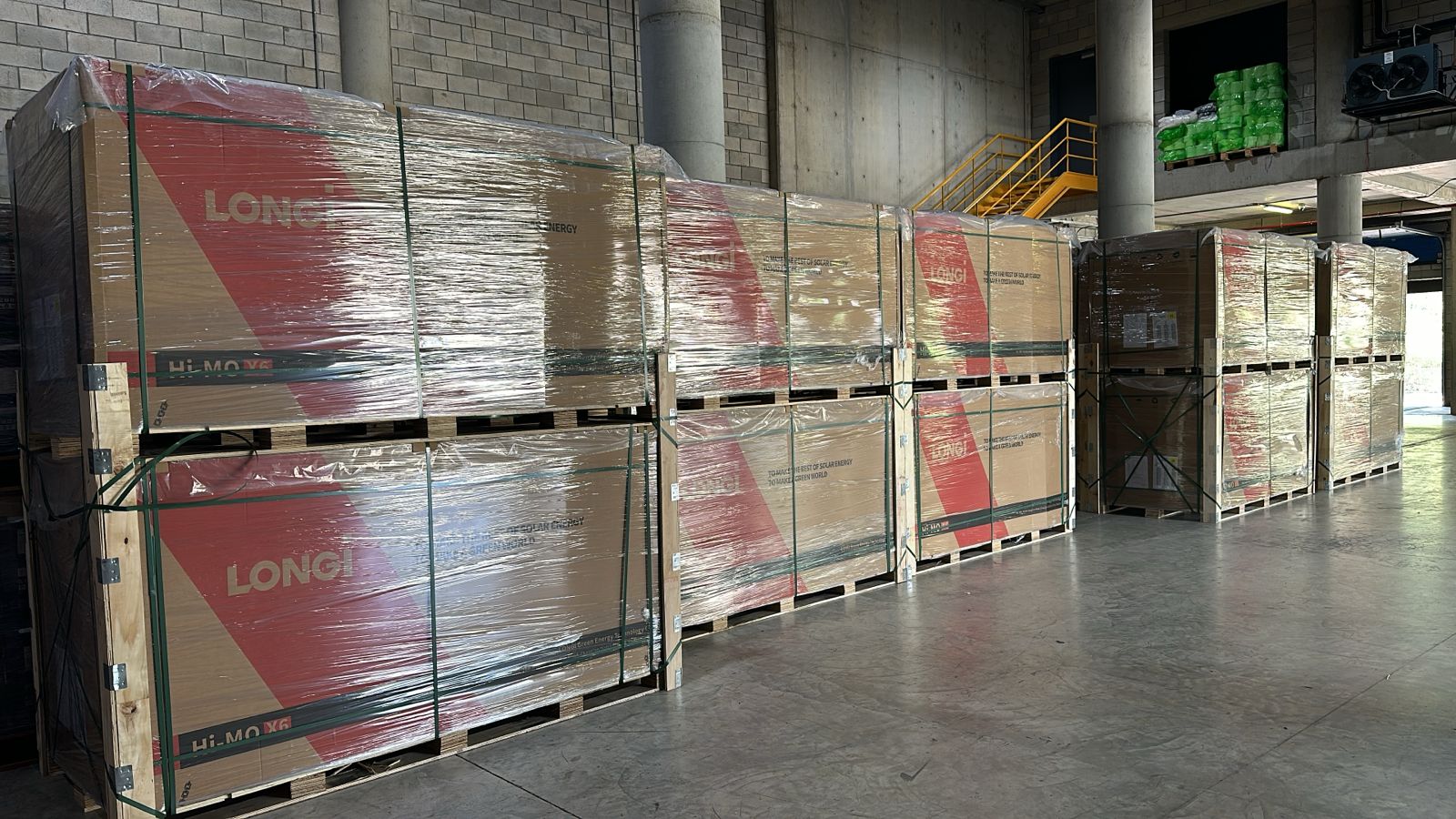 Wrapped LONGi Hi-MO panel pallets staged on the warehouse floor